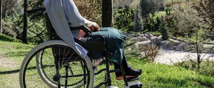 Amputation injury victim sitting in a wheelchair at the park