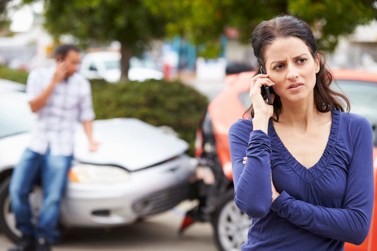 woman calling her attorney at car accident scene