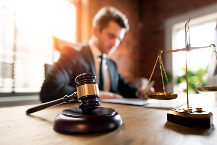 Lawyer working at desk with gavel and justice scales.